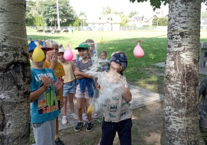 dzieci przebijają balony z wodą
