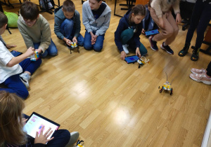 Uczniowie sprawdzają działanie zaprogramowanych robotów