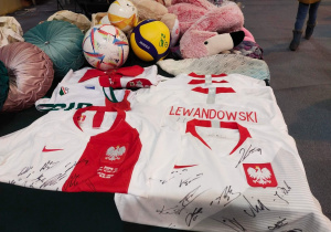 Główne stoisko darów do licytacji, koszulki z autografami piłkarzy Reprezentacji Polski w piłce nożnej, pluszaki, piłki z autografami